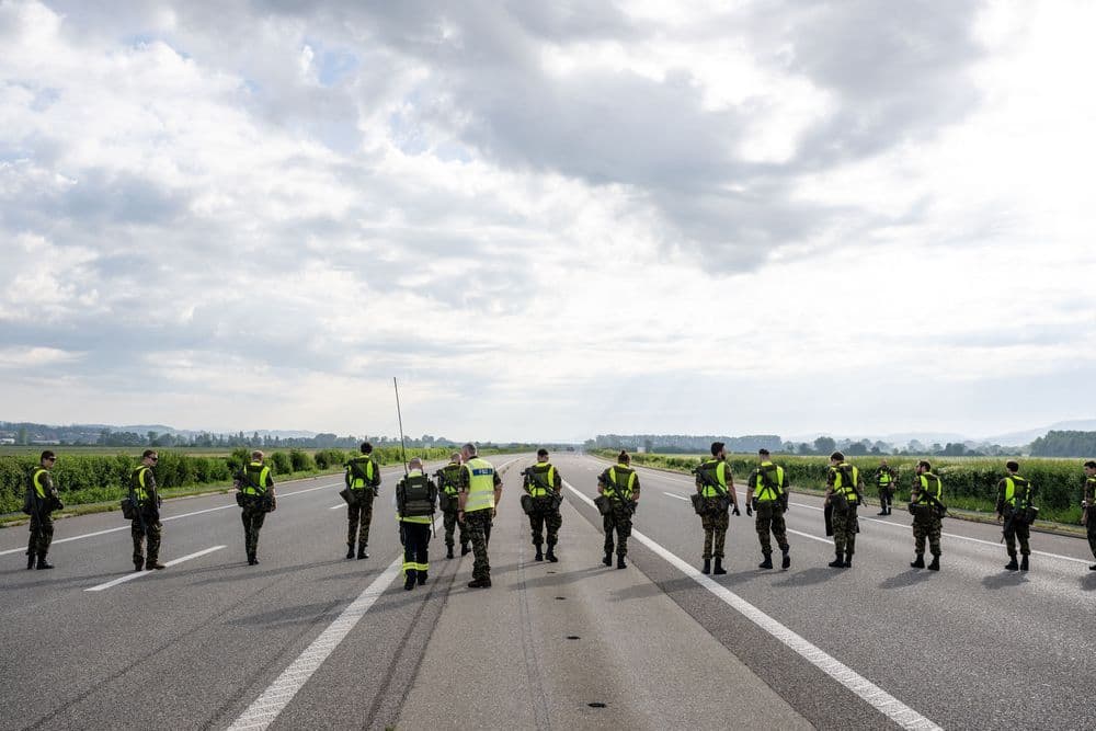 Soldaten in gelben Warnwesten überprüfen die Landebahn nach einer Landung eines Kampfjets.