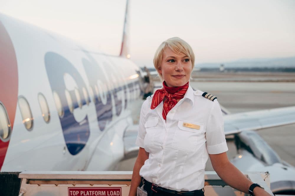 Eine Airlinepilotin steht auf der Flugzeugtreppe und wartet auf die Passagiere