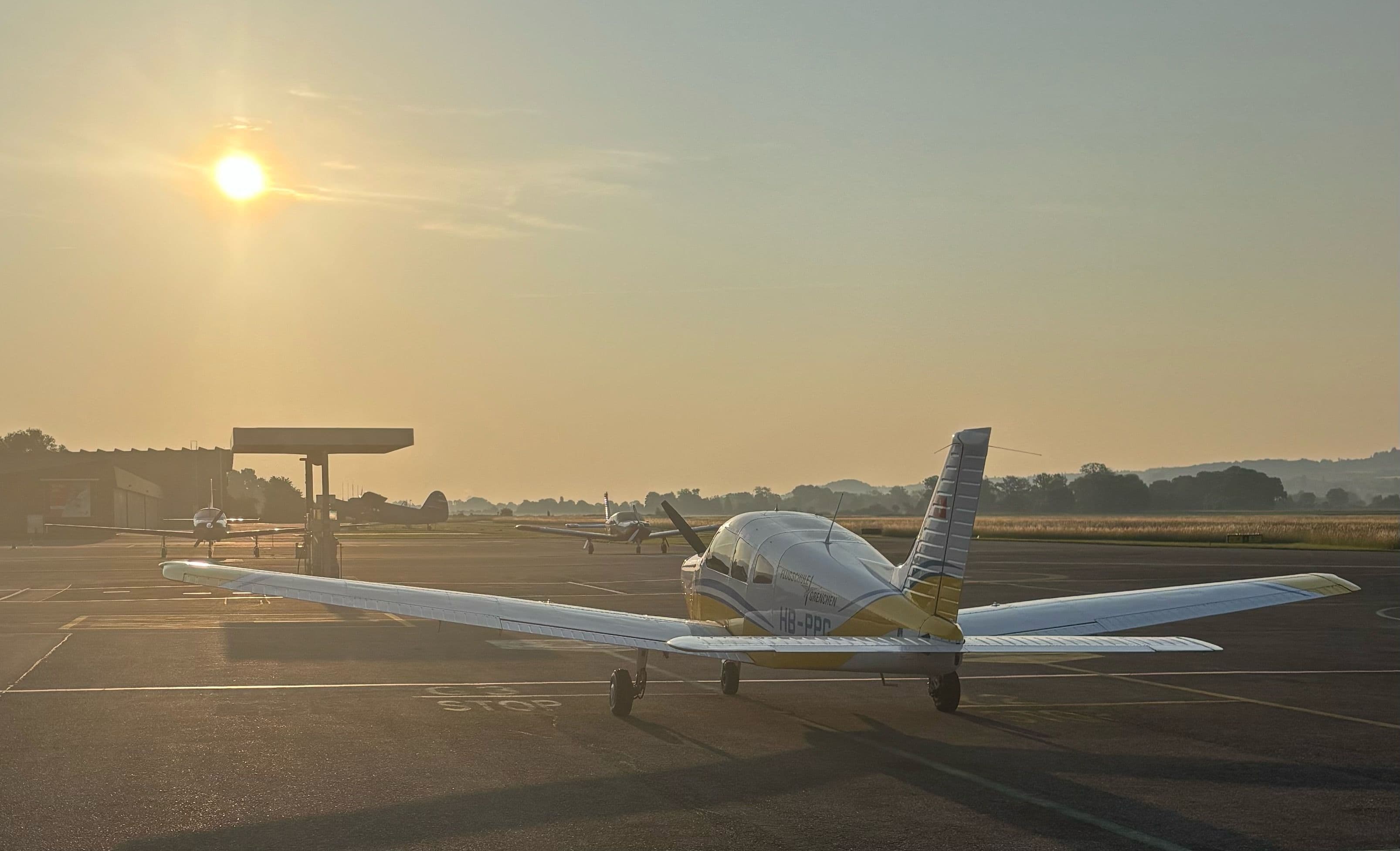 Ein Flugzeug bei Sonnenuntergang auf dem Tarmac.