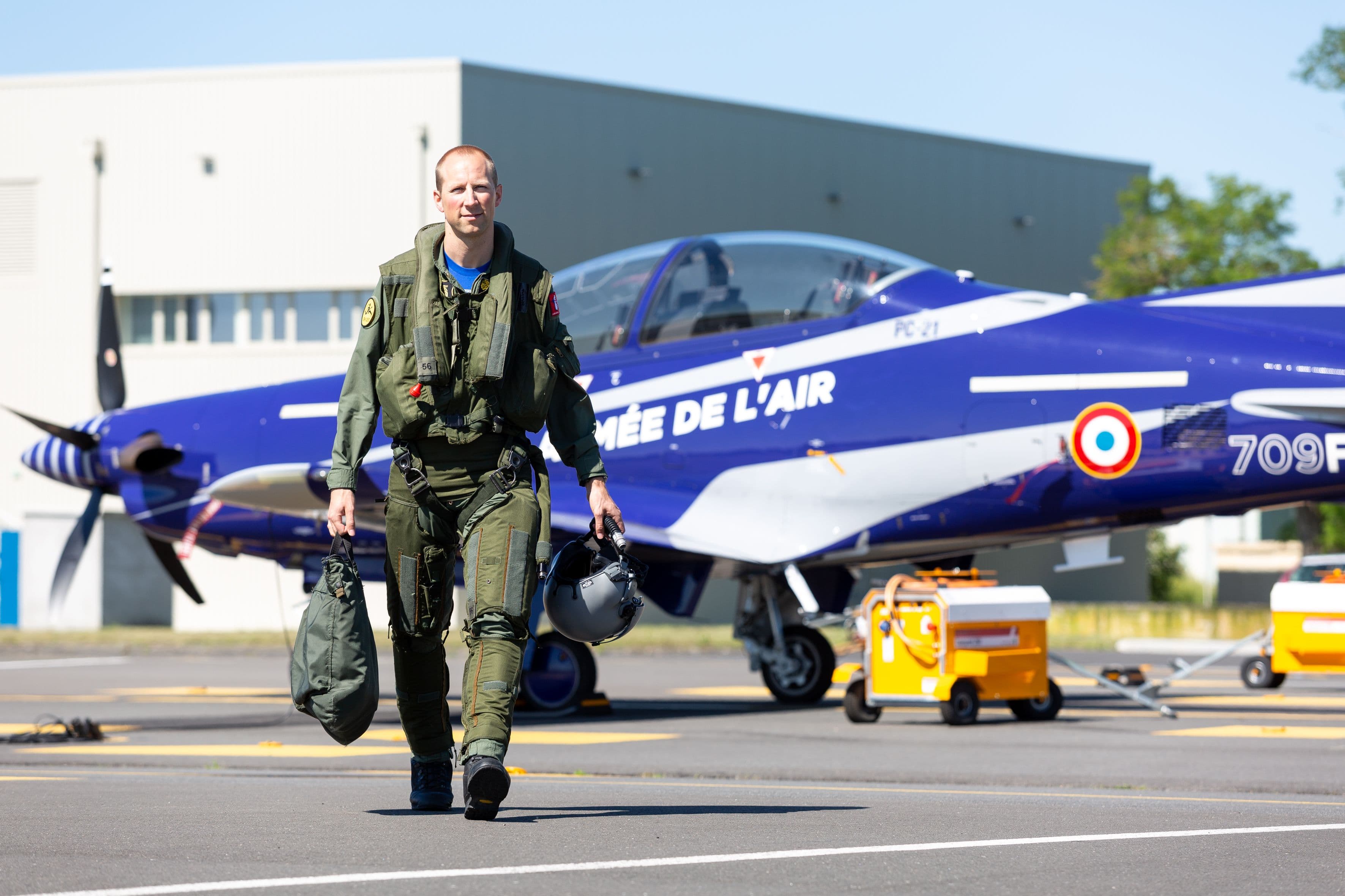 Ein Schweizer Militärpilot vor einem blauen PC-21 der Armée de l'air